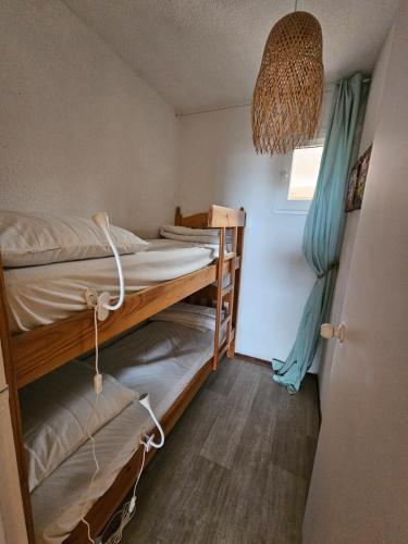 une chambre avec deux lits superposés et une fenêtre dans l'établissement Capbreton - Vue Océan - Famille - Surf - Plage, à Capbreton