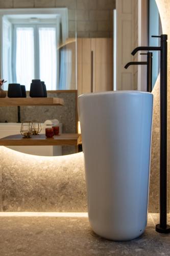 a white cup sitting on top of a counter at Fortunella Suites Luxury in Portici