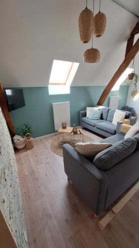 a living room with a couch and a tv at Spring Lodge - La grange aux quatres saisons - Pairi Daiza in Brugelette