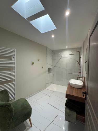 a bathroom with a sink and a shower with a skylight at La remise d'Edouard in Saint-Papoul