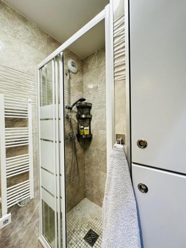 une douche avec une porte vitrée dans une salle de bain dans l'établissement New Cozy Apartment in Paris center metro 7 & 14, à Paris