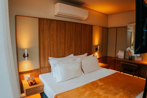 a hotel room with a bed with white pillows at Duke Beach Hotel Maresias in Maresias