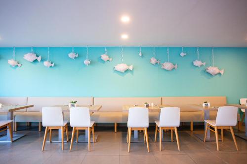 a restaurant with a table with white chairs and a blue wall at BQ Sarah -Adults Only in Can Picafort