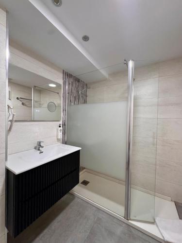 a bathroom with a sink and a shower at Color Suites Alicante in Alicante