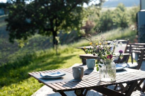 a wooden table with a vase of flowers on it at Agriturismo Glamping Pettirosso in Fratta Terme