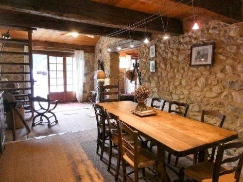 - une table en bois dans une chambre dotée d'un mur en pierre dans l'établissement Maison de charme sous le soleil de la Drôme, à Châtillon-en-Diois