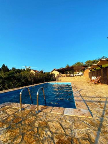 a large swimming pool with a resort at Just Joy Apartman in Vrdnik