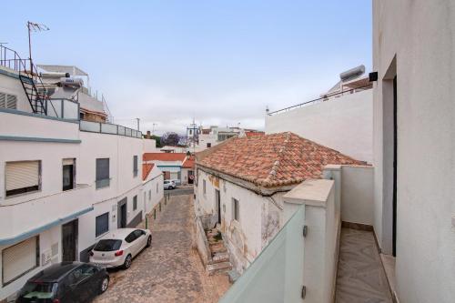 an alley between two buildings with a car parked at Villa Alvor Rooftop in Alvor