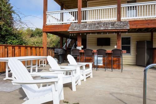 a group of white chairs and tables on a patio at Whalehead Adventure With Ocean Views Pool Spa in Corolla