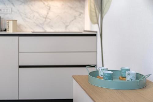 a tray with cups on a counter in a kitchen at Luxury Sofia Home Alghero in Alghero