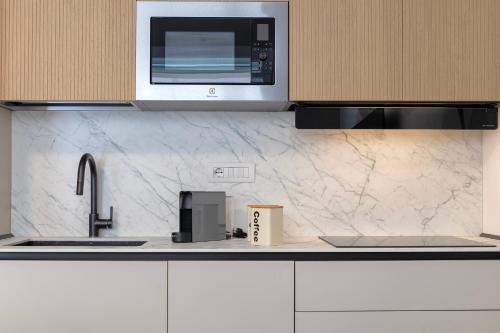 a kitchen with a sink and a microwave at Luxury Sofia Home Alghero in Alghero