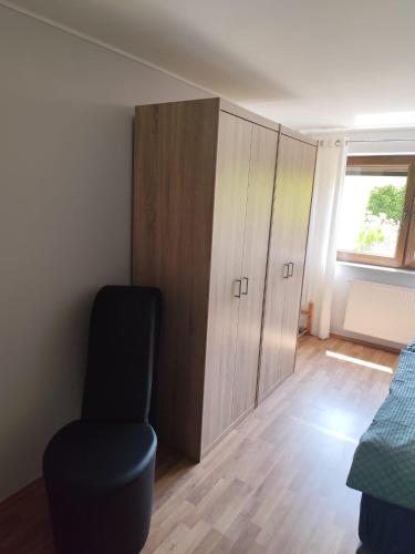 a room with a chair and a cabinet and a window at Ferienwohnung Obsthof Lutz - nur Urlaubsgäste in Fisch