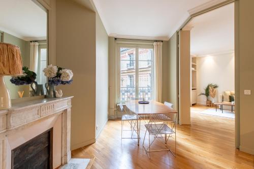 - un salon avec une cheminée, une table et des chaises dans l'établissement Chic apartment 1BR-2P - Arc de Triomphe, à Paris