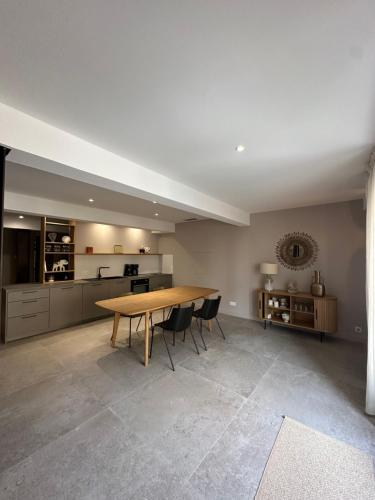 une grande cuisine avec une table et des chaises en bois dans l'établissement La remise d'Edouard, à Saint-Papoul