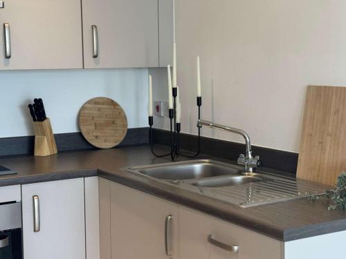 a kitchen with a sink and two candles on the counter at Luxury 1 bedroom, 1 bath apartment by MCF in Horley
