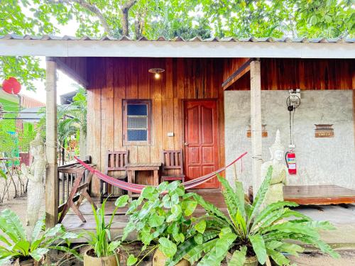 a house with a red door and some plants at Sea Paradise Klongkoi beach in Ban Khlong Kloi
