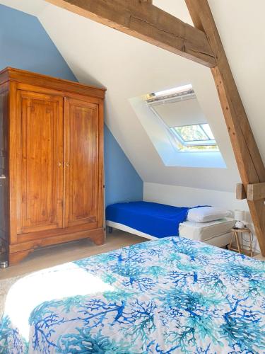 Un dormitorio con una cama y un armario de madera. en Gîte Gabrielle au cœur des Caps et Marais d'Opale, en Licques