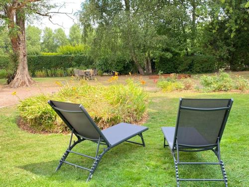 dos sillas y una mesa en el césped en Gîte Gabrielle au cœur des Caps et Marais d'Opale, en Licques