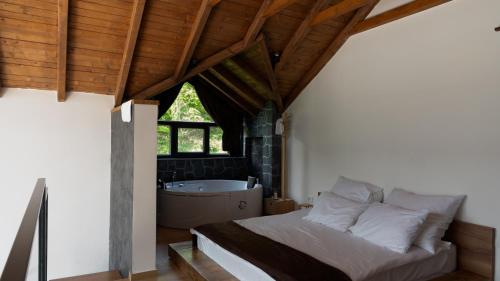 a bedroom with a bed and a bath tub at Ren Villas in Mavrovo