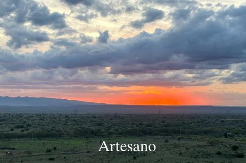 a sunset in the middle of a field with clouds at Deluxe Private Studio Pad JKIA SGR in Nairobi
