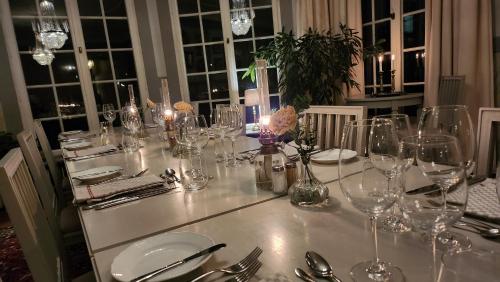 a table with wine glasses and utensils on it at Villa Gransholm in Gemla