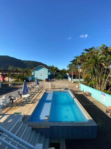 a swimming pool with two lounge chairs at Chalés Céu e Mar Ubatuba in Ubatuba