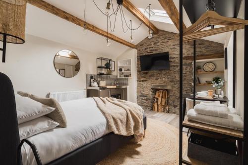 a bedroom with a bed and a stone wall at Ferry View Studio with Hot Tub and Parking in Bowness-on-Windermere