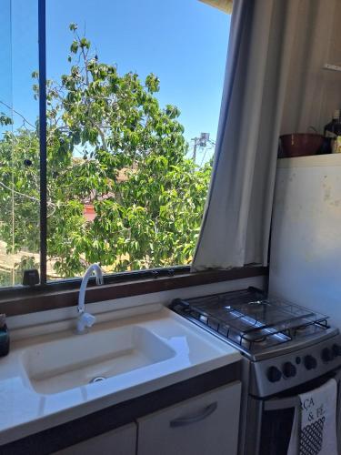 a kitchen with a sink and a window at Bora Bora Geribá Kitnet in Búzios