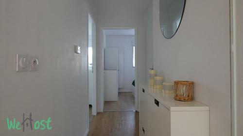 un couloir aux murs blancs et une chambre avec une table dans l'établissement Appart terrasse privée parking proche mer, à Pornichet
