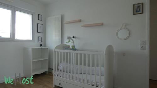 une pépinière blanche avec un berceau et une fenêtre dans l'établissement Appart terrasse privée parking proche mer, à Pornichet