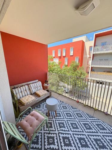 - un balcon avec un canapé, une table et une chaise dans l'établissement T2 Air conditioning Terrace & Parking near Montpellier, à Juvignac
