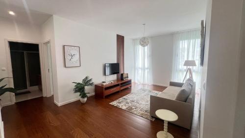 a living room with a couch and a tv at City Center House - Azure Waters in Ribeira Grande