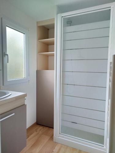 - une porte en verre dans la cuisine équipée d'un réfrigérateur dans l'établissement Mobil home cosy dans camping 4 étoiles, à Pleubian