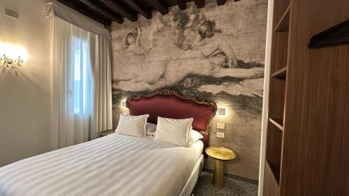 a bedroom with a bed with a painting on the wall at Ai Due Fanali Adults Only in Venice