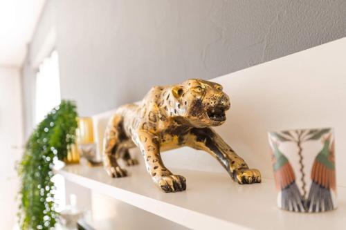 une statue d'un chien assis sur une étagère dans l'établissement Résidence Saint-Vincent Elegance et Comfort, à Venteuil