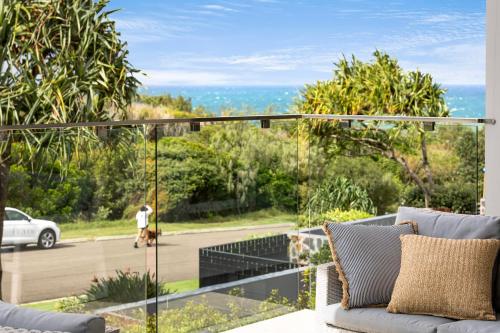 a balcony with a view of a person walking a dog at Seaside Luxury: Private Pool and Stunning Views in Yaroomba