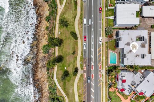 an aerial view of a road next to the ocean at Amalfi on Alex: Seaside 2 Bedroom Retreat in Alexandra Headland