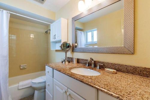 a bathroom with a sink and a toilet and a mirror at Crescent Royale Condominiums 301 in Siesta Key