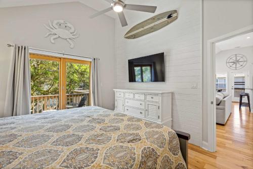 a bedroom with a bed and a tv in a room at Oceanside retreat with pool & spa June Weeks Open in Sanderling