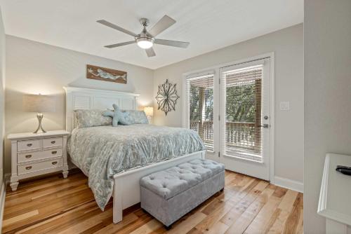 a bedroom with a bed and a ceiling fan at Oceanside retreat with pool & spa June Weeks Open in Sanderling