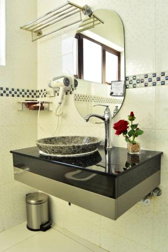 a bathroom counter with a sink and a mirror at Polka GuestHouse in Tshabong
