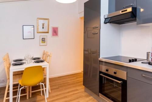 une cuisine avec une petite table et des chaises jaunes dans l'établissement 4-person apartment, city center, à Caen