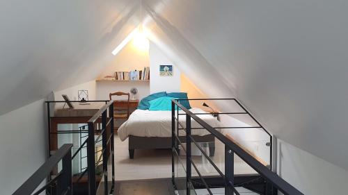 - une chambre mansardée avec un lit et un escalier dans l'établissement Maison La Passerelle, à Kervoz