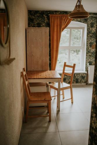 a table and chairs in a room with a window at Park Hotelik II Piętro in Mielno