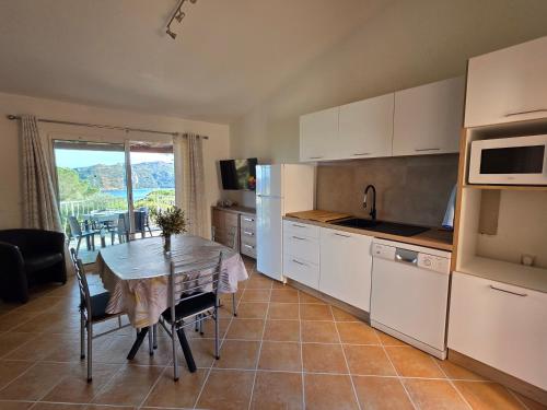 une cuisine avec une table et une salle à manger dans l'établissement Mini villa Paesolu, à Porto-Vecchio