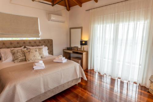 a bedroom with a bed with two towels on it at Olive Grove Villa in Koropíon