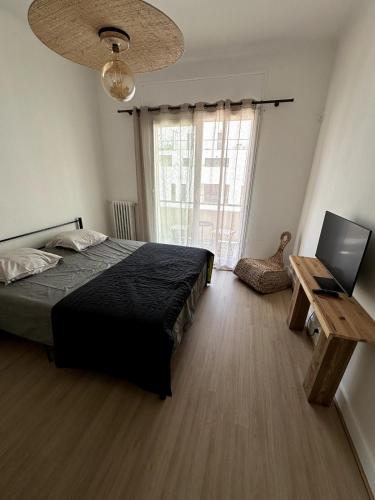 une chambre avec un lit, une table et une fenêtre dans l'établissement Studio Prado near Velodrome, à Marseille