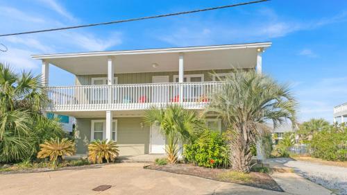 una casa con balcone e palme di Holiday House a Destin