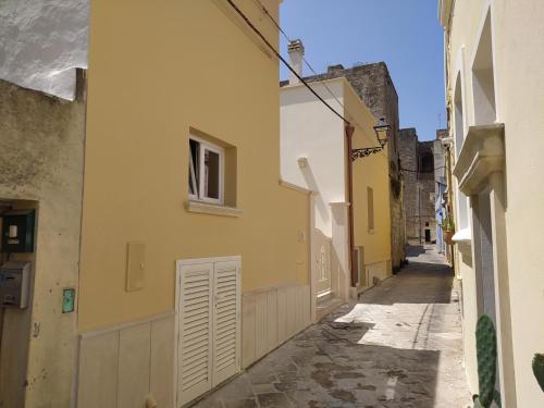 an alley with yellow buildings and a window at Casa Vacanza Al Vicolo della Colonna nel centro storico di Presicce in Presicce