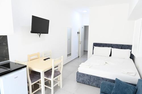 Habitación con cama, mesa y escritorio. en Apartaments Tafi Holiday, en Shëngjin